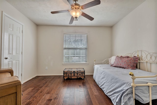 bedroom with a ceiling fan, wood-type flooring, baseboards, and a textured ceiling