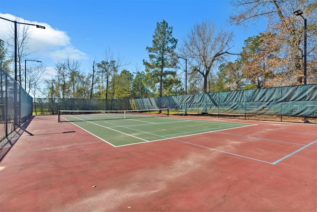 view of tennis court featuring fence