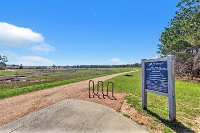 view of community with a yard and a rural view