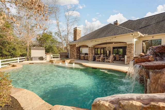 outdoor pool with ceiling fan, a patio area, a fireplace, and fence