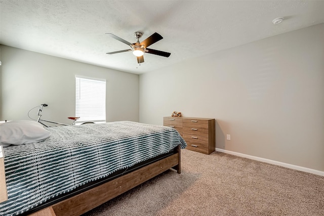 bedroom with light carpet, ceiling fan, baseboards, and a textured ceiling