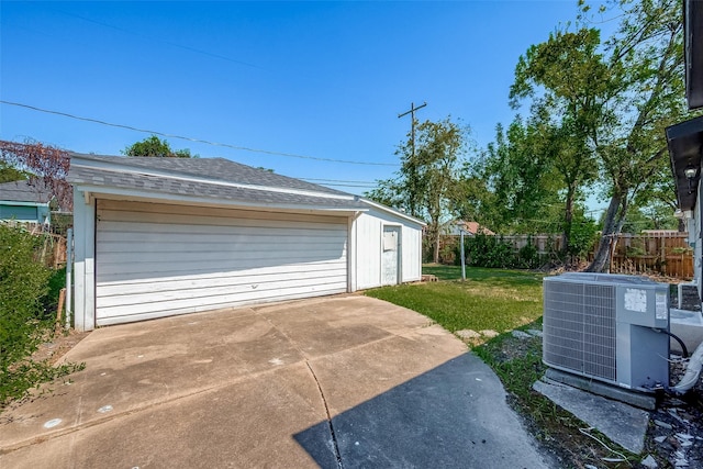 detached garage featuring fence and central air condition unit