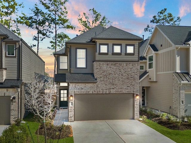 view of front of property with a shingled roof, concrete driveway, brick siding, and an attached garage