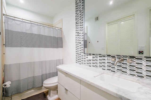 bathroom featuring visible vents, decorative backsplash, a shower with shower curtain, toilet, and vanity