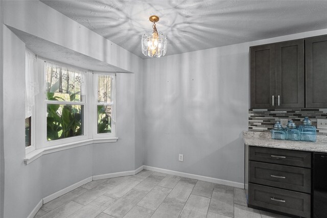 dining room featuring a notable chandelier and baseboards