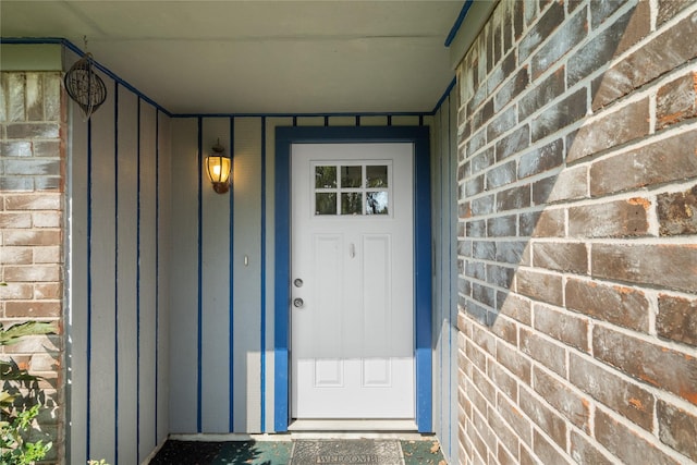 doorway to property featuring brick siding