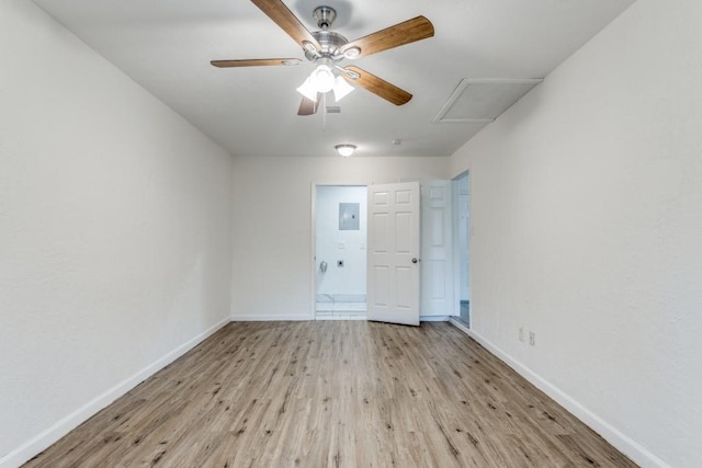 unfurnished room with attic access, ceiling fan, light wood-style flooring, and baseboards