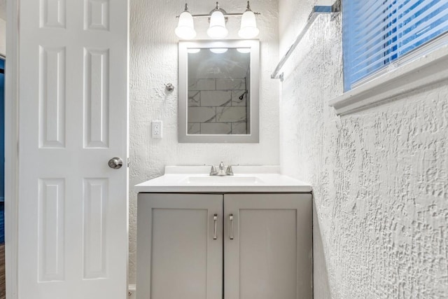 bathroom featuring a textured wall and vanity