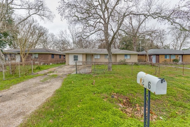 single story home with driveway, a fenced front yard, a front lawn, and brick siding