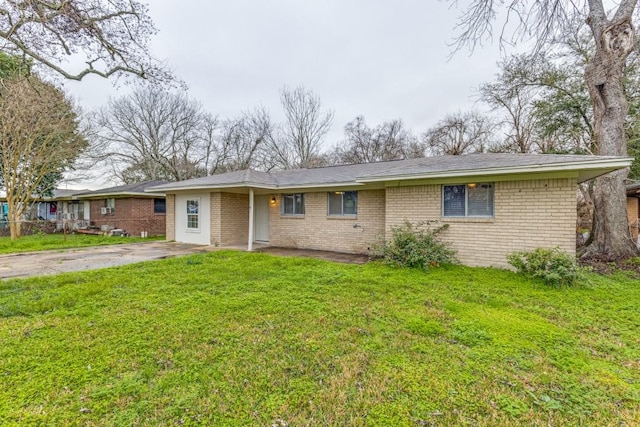 ranch-style home with a front yard, brick siding, and driveway