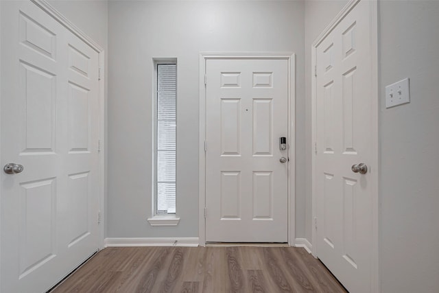 foyer entrance with baseboards and light wood-style floors