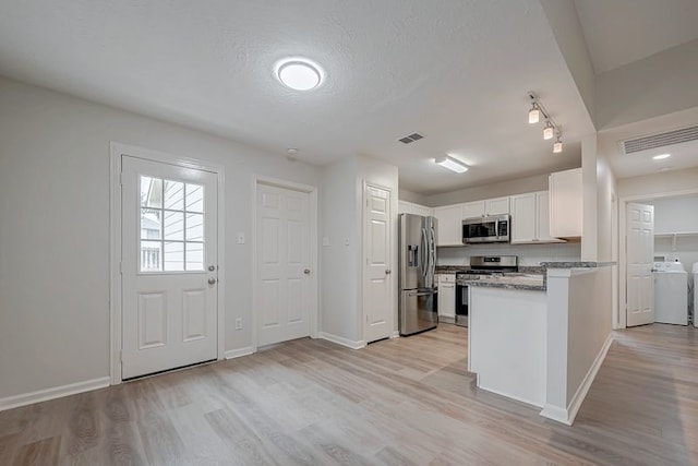 kitchen with visible vents, appliances with stainless steel finishes, white cabinets, and light stone counters