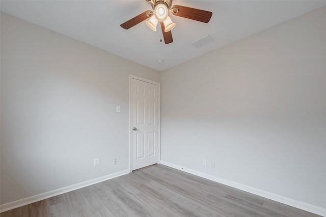 unfurnished room with ceiling fan, baseboards, visible vents, and light wood-style flooring