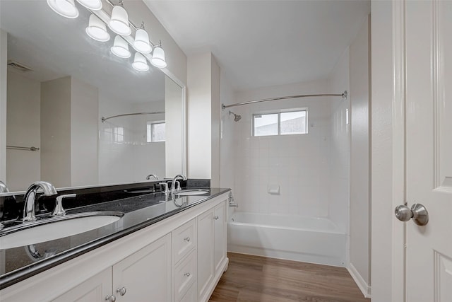 bathroom with  shower combination, visible vents, a sink, and wood finished floors