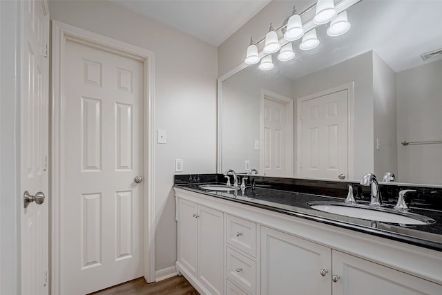 full bath featuring double vanity, wood finished floors, a sink, and visible vents