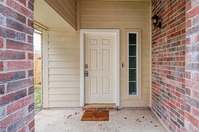 doorway to property with brick siding