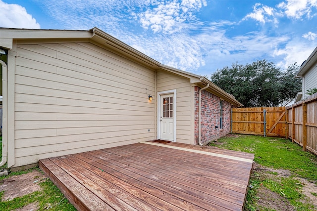 wooden terrace with a fenced backyard and a gate