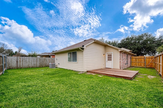 rear view of property featuring a fenced backyard, a lawn, brick siding, and central AC unit