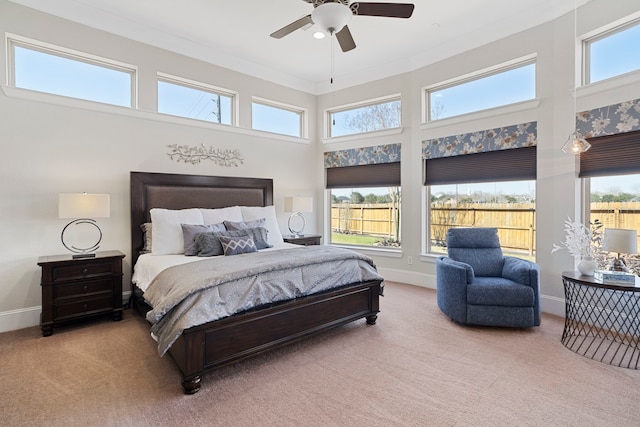 bedroom featuring carpet, a towering ceiling, a ceiling fan, ornamental molding, and baseboards