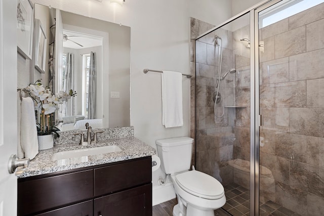 full bathroom featuring a stall shower, vanity, toilet, and wood finished floors