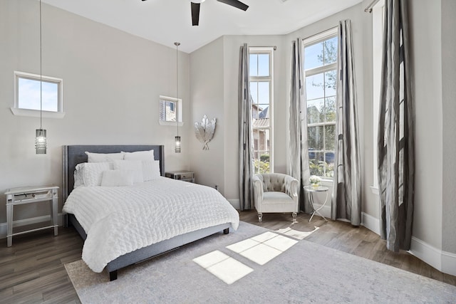 bedroom featuring ceiling fan, baseboards, and wood finished floors