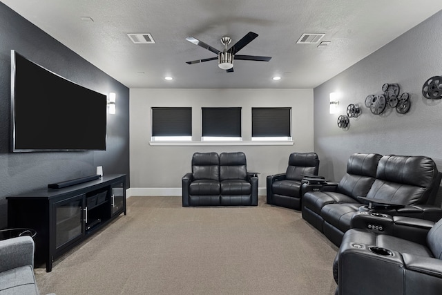 cinema room featuring ceiling fan, a textured ceiling, light carpet, visible vents, and baseboards