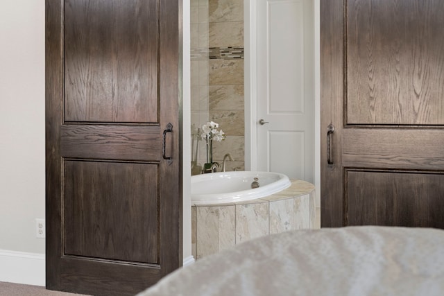 bathroom featuring a relaxing tiled tub and tile walls