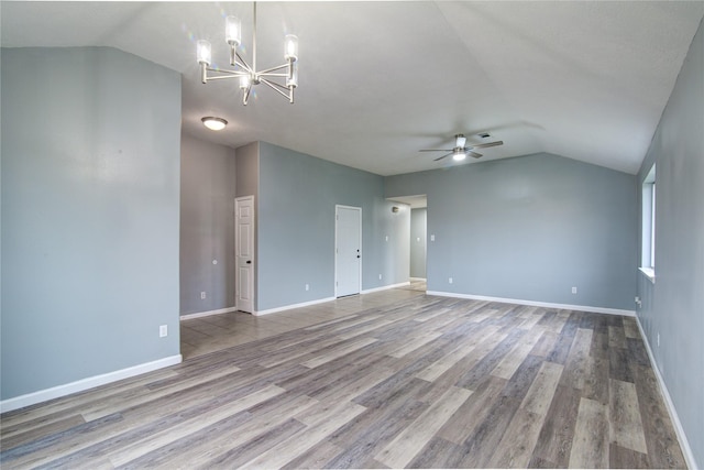 empty room featuring lofted ceiling, ceiling fan with notable chandelier, baseboards, and light wood-style floors