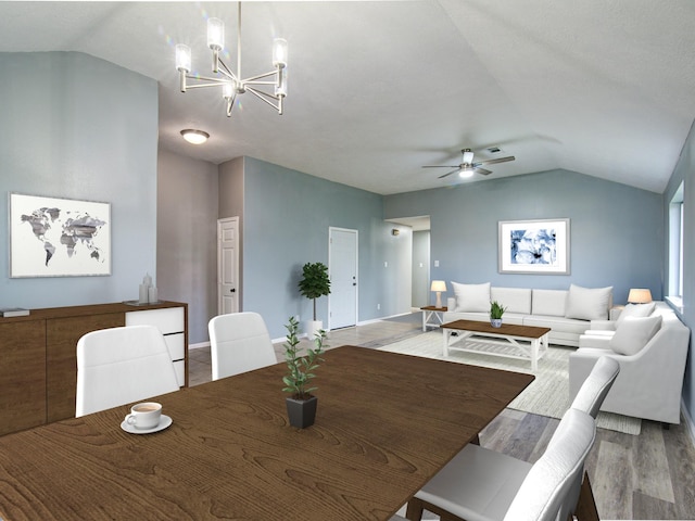 dining space featuring vaulted ceiling, light wood-style flooring, baseboards, and ceiling fan with notable chandelier