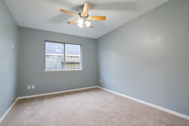 carpeted empty room featuring ceiling fan and baseboards