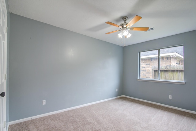 empty room with ceiling fan, visible vents, baseboards, and light colored carpet