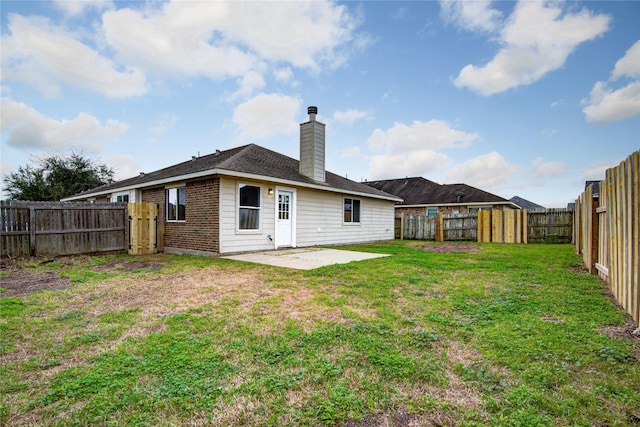 back of house featuring a fenced backyard, brick siding, a lawn, a chimney, and a patio area