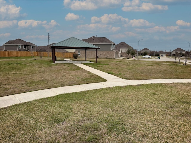 view of community with a yard, a residential view, fence, and a gazebo