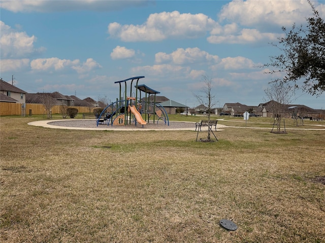 community playground featuring a residential view, fence, and a lawn