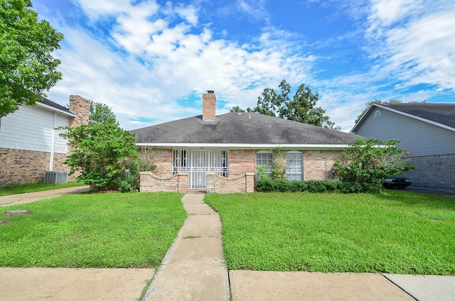 single story home featuring a shingled roof, brick siding, a chimney, and a front lawn