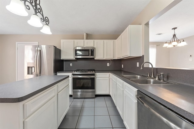 28907 Sedgefield St, Spring, TX 77386 - kitchen featuring stainless steel appliances, a sink, dark countertops, and light tile patterned floors