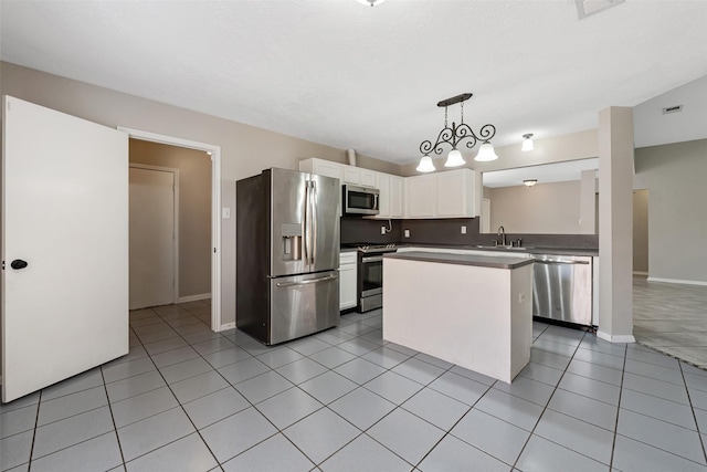 28907 Sedgefield St, Spring, TX 77386 - kitchen featuring appliances with stainless steel finishes, white cabinetry, light tile patterned floors, baseboards, and decorative light fixtures
