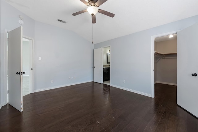 28907 Sedgefield St, Spring, TX 77386 - unfurnished bedroom with lofted ceiling, dark wood-style flooring, a walk in closet, baseboards, and connected bathroom