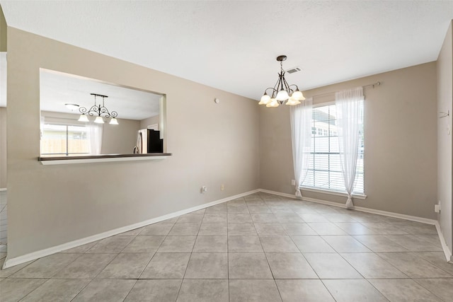 28907 Sedgefield St, Spring, TX 77386 - empty room featuring a chandelier, light tile patterned floors, healthy amount of natural light, and baseboards