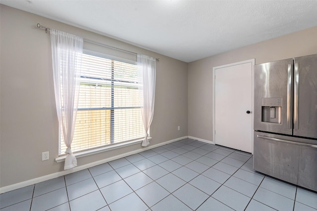 28907 Sedgefield St, Spring, TX 77386 - kitchen with stainless steel refrigerator with ice dispenser, light tile patterned flooring, and baseboards