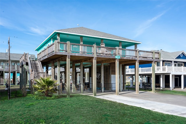 rear view of property featuring a carport, a yard, and a shingled roof