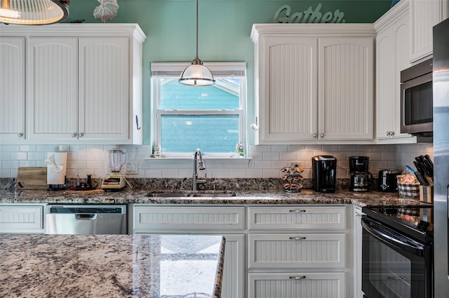 kitchen featuring a sink, white cabinets, hanging light fixtures, appliances with stainless steel finishes, and decorative backsplash