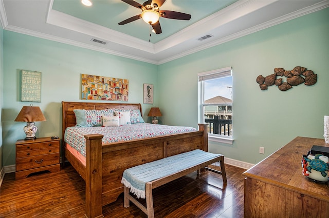 bedroom with visible vents, a raised ceiling, and dark wood-type flooring