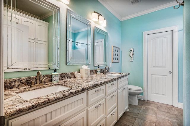 full bathroom with crown molding, a sink, toilet, and double vanity