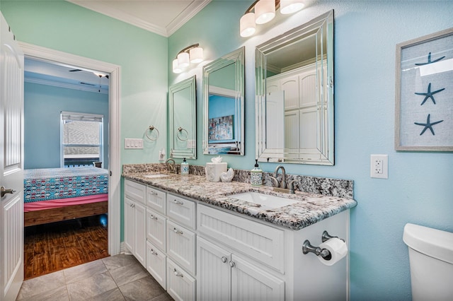 bathroom featuring ornamental molding, double vanity, a sink, and ensuite bathroom