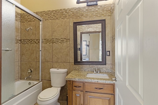 bathroom featuring toilet, shower / bath combination, tile walls, and vanity