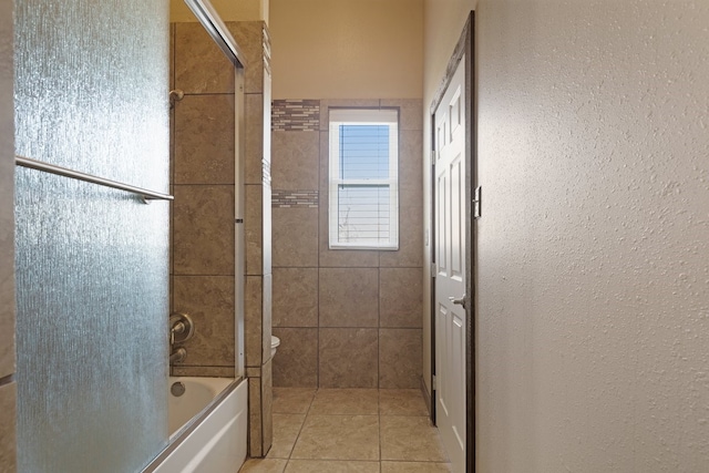 full bathroom featuring tile patterned flooring, combined bath / shower with glass door, and toilet