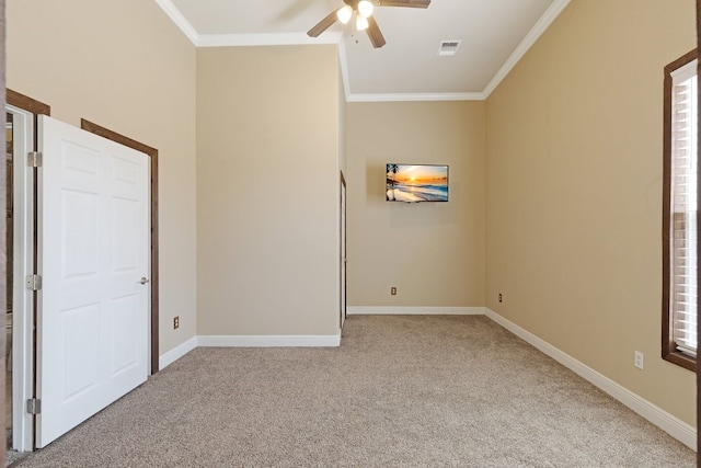 unfurnished bedroom with light colored carpet, visible vents, crown molding, and baseboards