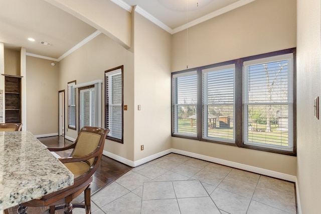 dining room with baseboards, light tile patterned flooring, visible vents, and crown molding