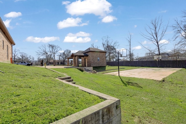 view of yard featuring community basketball court and fence